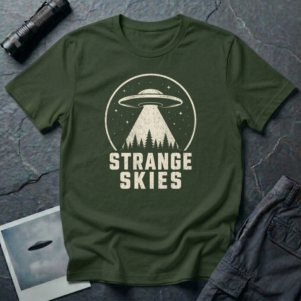 Military green retro UFO t-shirt with a flying saucer and tractor beam over a conifer forest inside a distressed circle with the words STRANGE SKIES in white