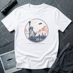 The Latest Arrival UFO t-shirt with Statue of Liberty greeting a descending saucer in engraved style, white tee
