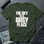 Military green t-shirt with bold white text reading The Sky Is A Busy Place and small UFO silhouette