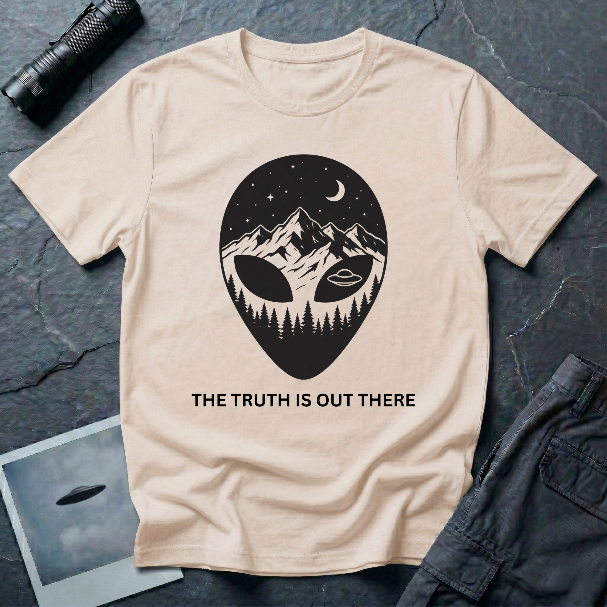 The Truth Is Out There alien head t-shirt — alien silhouette filled with mountains, pine forest and flying saucer on natural cotton tee