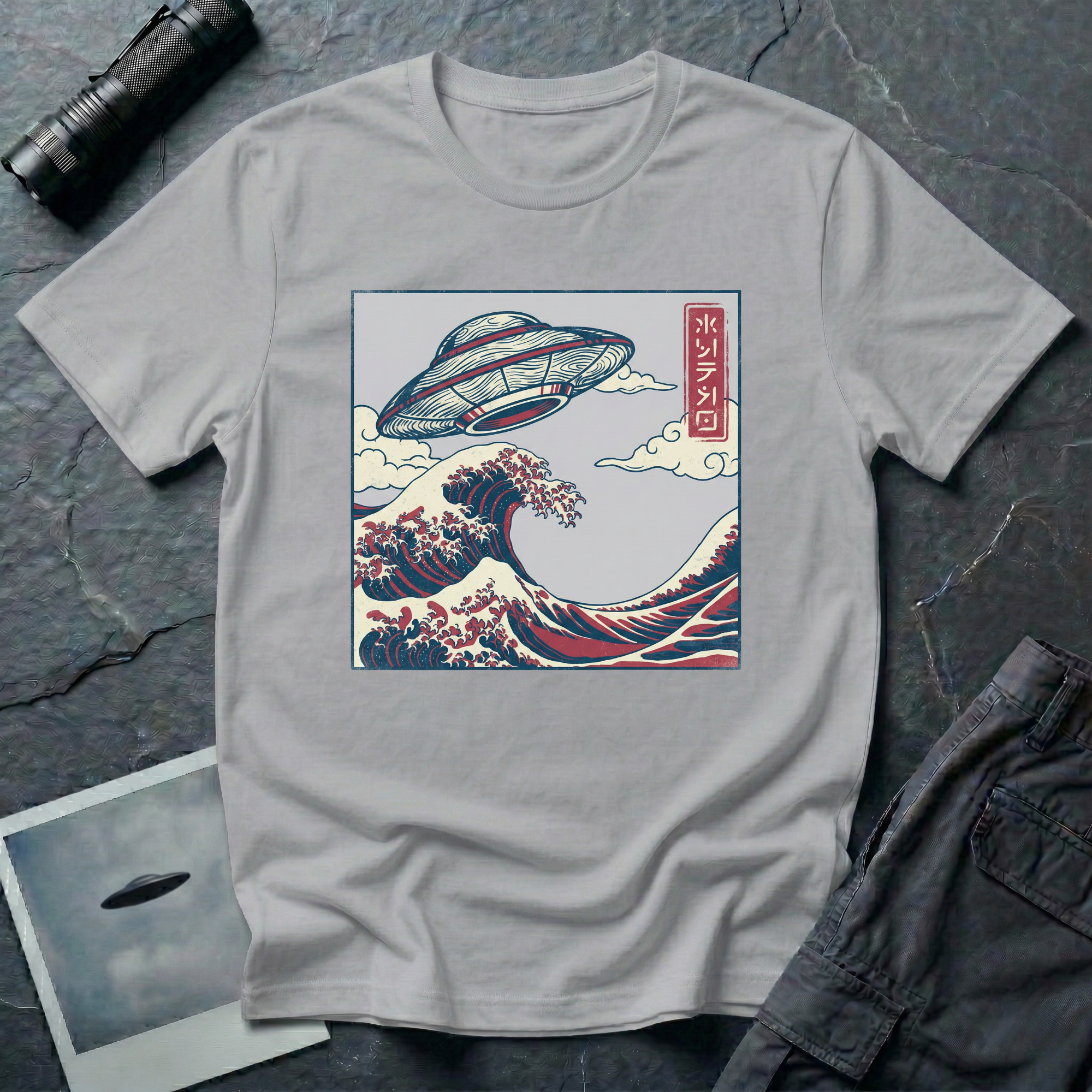 The Wave Japanese woodblock UFO t-shirt — flying saucer above Hokusai-style cresting wave in indigo and red on grey cotton tee