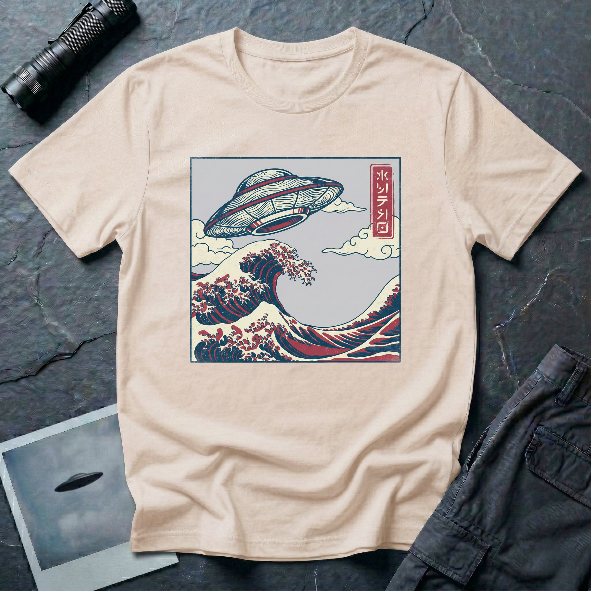 The Wave Japanese woodblock UFO t-shirt — flying saucer above Hokusai-style cresting wave in indigo and red on natural cotton tee