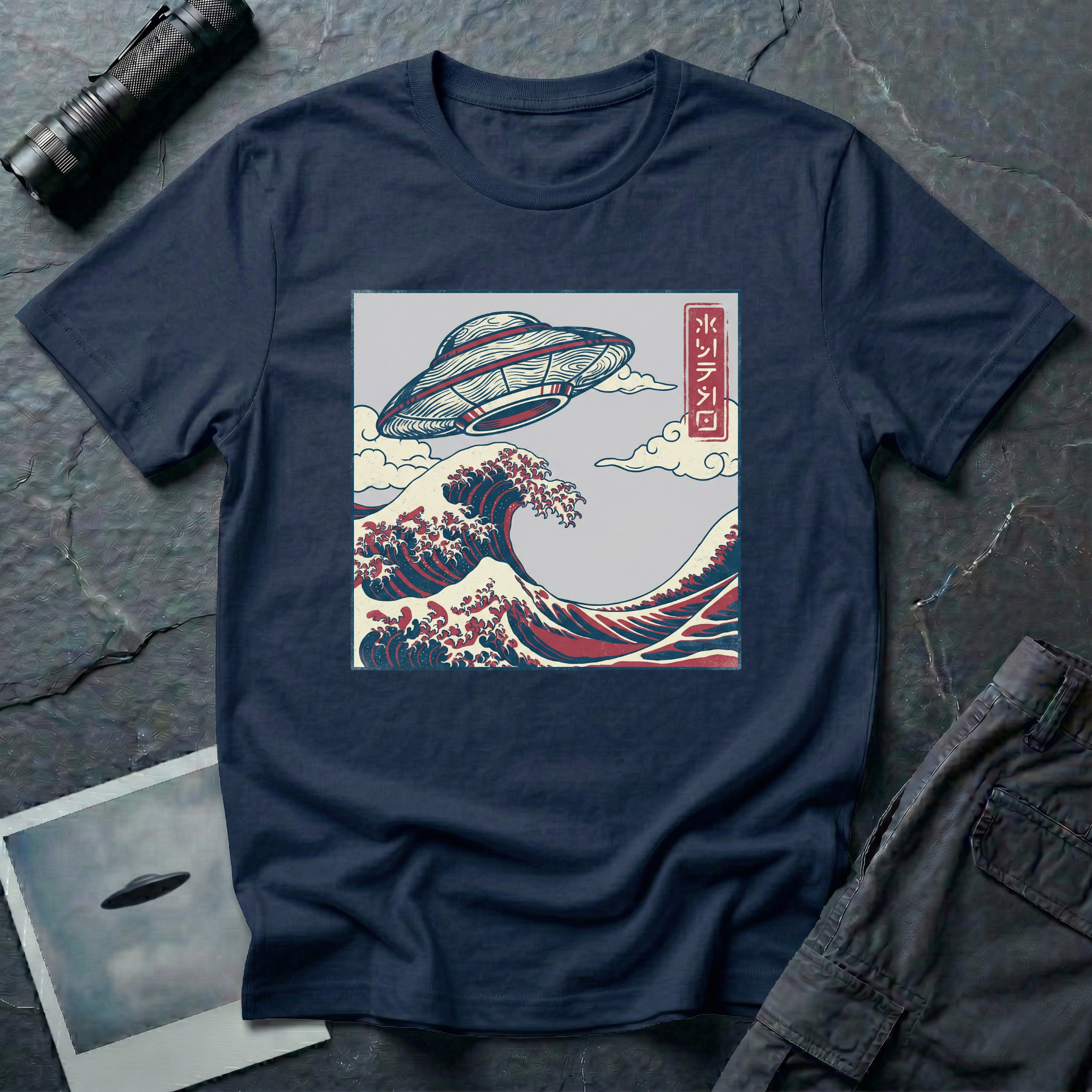 The Wave Japanese woodblock UFO t-shirt — flying saucer above Hokusai-style cresting wave in indigo and red on navy blue cotton tee