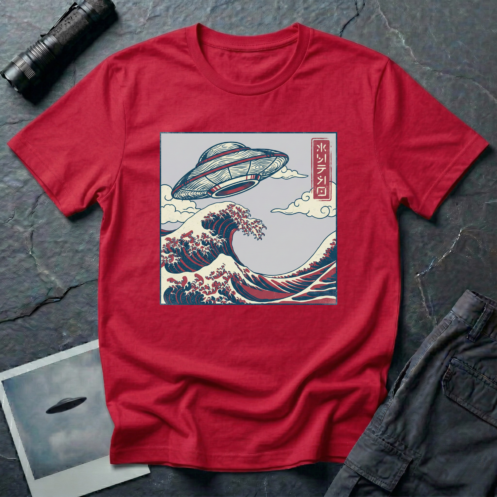 The Wave Japanese woodblock UFO t-shirt — flying saucer above Hokusai-style cresting wave in indigo and red on red cotton tee