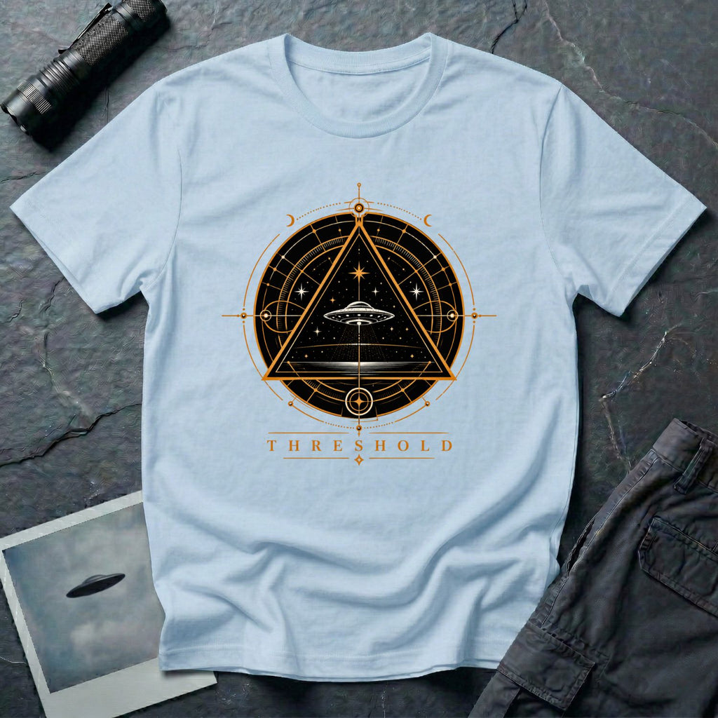 Light blue UFO t-shirt with a flying saucer inside an upward-pointing triangle portal with perspective grid, crescent moons, and compass frame in gold and black with the word THRESHOLD