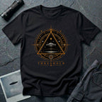 Black UFO t-shirt with a flying saucer inside an upward-pointing triangle portal with perspective grid, crescent moons, and compass frame in gold and black with the word THRESHOLD