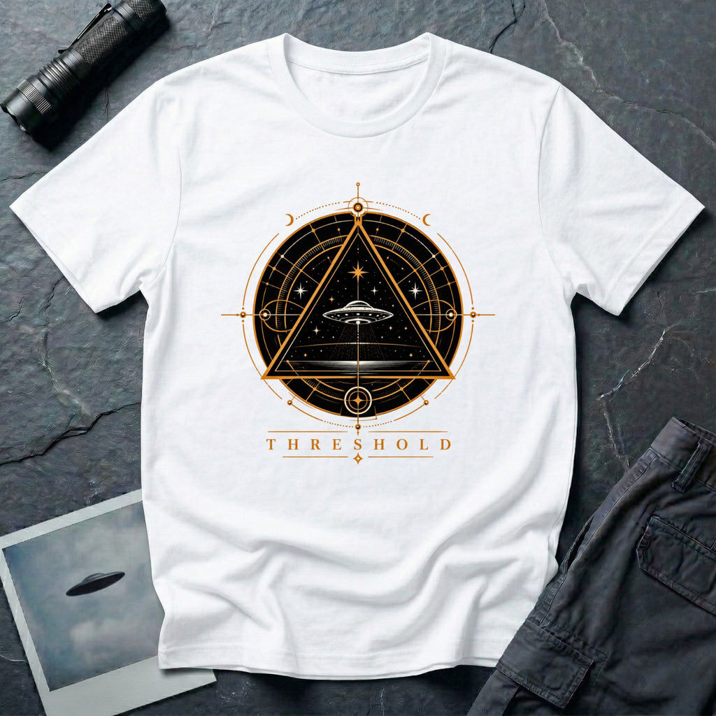 White UFO t-shirt with a flying saucer inside an upward-pointing triangle portal with perspective grid, crescent moons, and compass frame in gold and black with the word THRESHOLD
