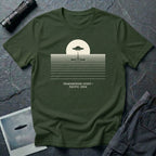 T-shirt with UFO above rippling ocean horizon lines and Transmedium Event Pacific 2004 caption, military green