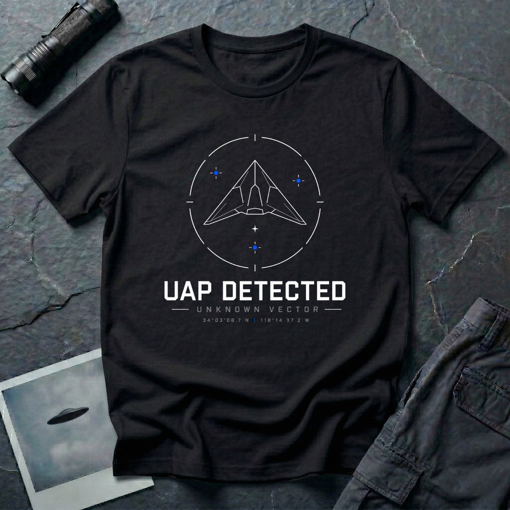 Black t-shirt with geometric angular UAP inside circular radar targeting reticle with UAP DETECTED UNKNOWN VECTOR text and GPS coordinates in white and blue linework