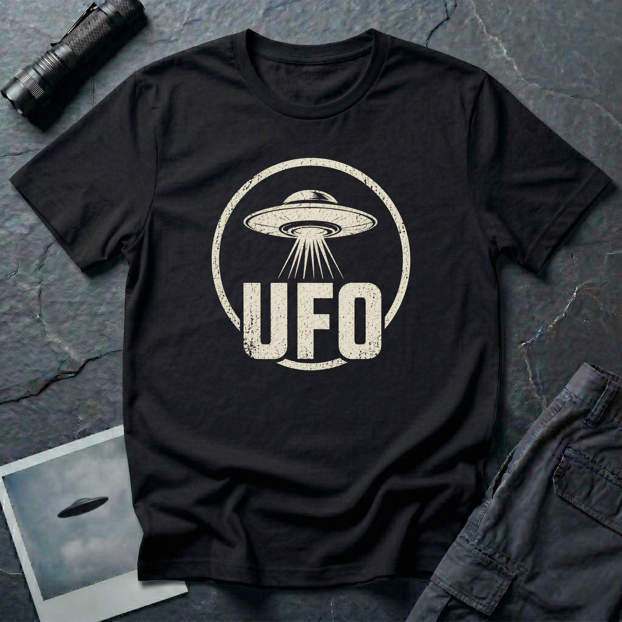 Black retro UFO t-shirt with a distressed circle containing a flying saucer with tractor beam and bold block letters spelling UFO in white