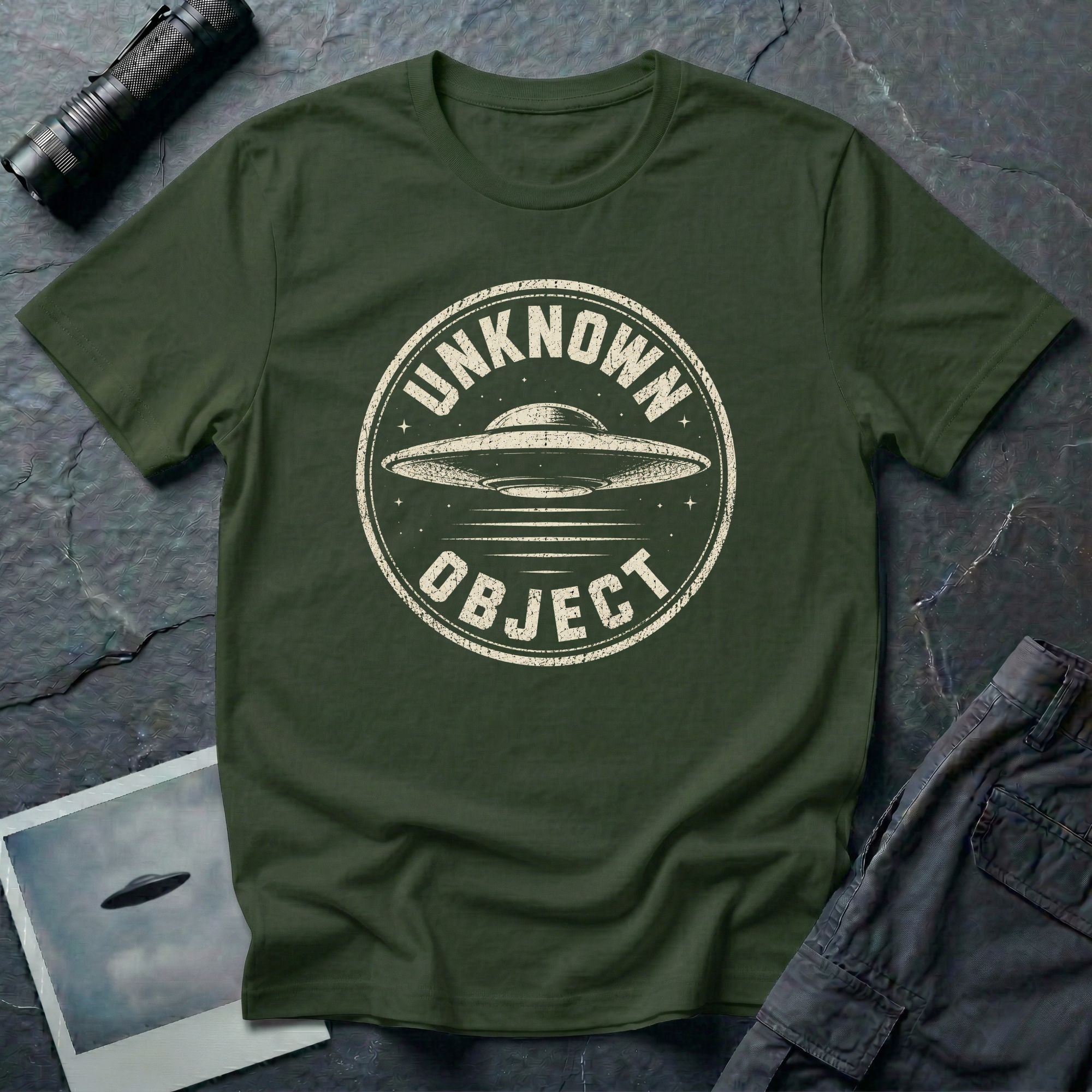Green retro UFO t-shirt with a distressed circular badge showing a flying saucer with speed lines and the words UNKNOWN OBJECT in white