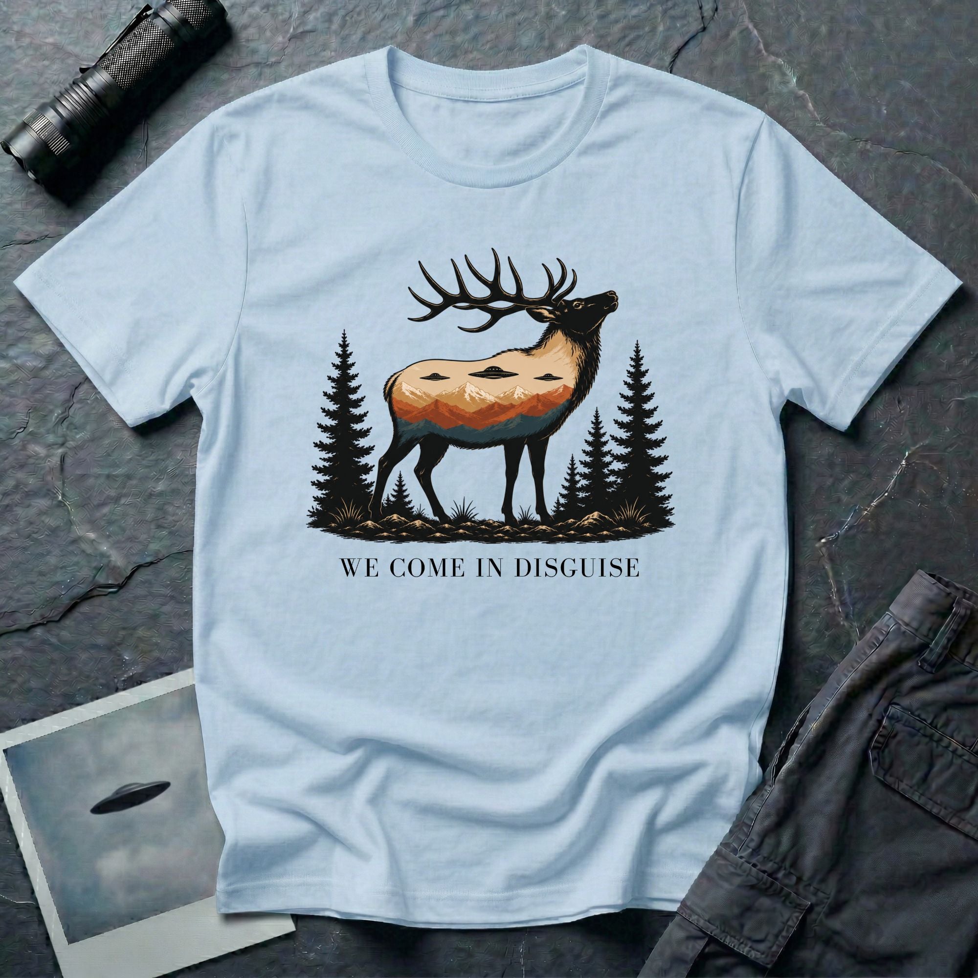We Come in Disguise UFO t-shirt with deer double exposure hiding three saucers in mountain skyline, light blue